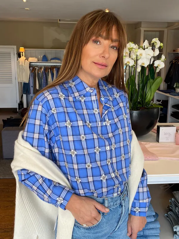 Collection Hiver 2026 : chemise à carreaux bleus et pull crème sur les épaules